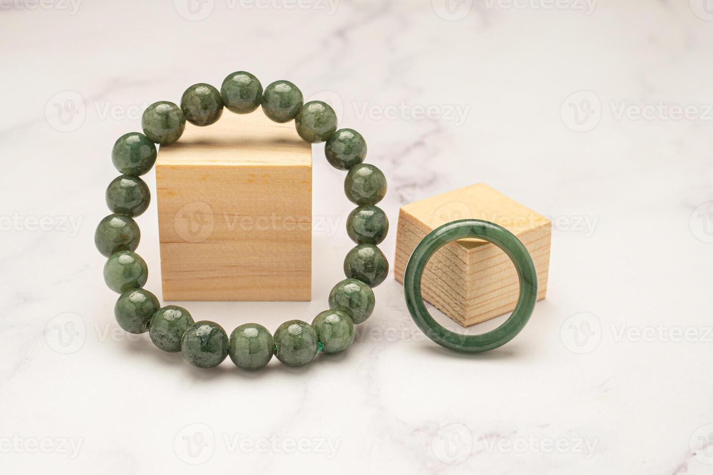 Jade bangle or bracelet and green jade ring on a marble table photo