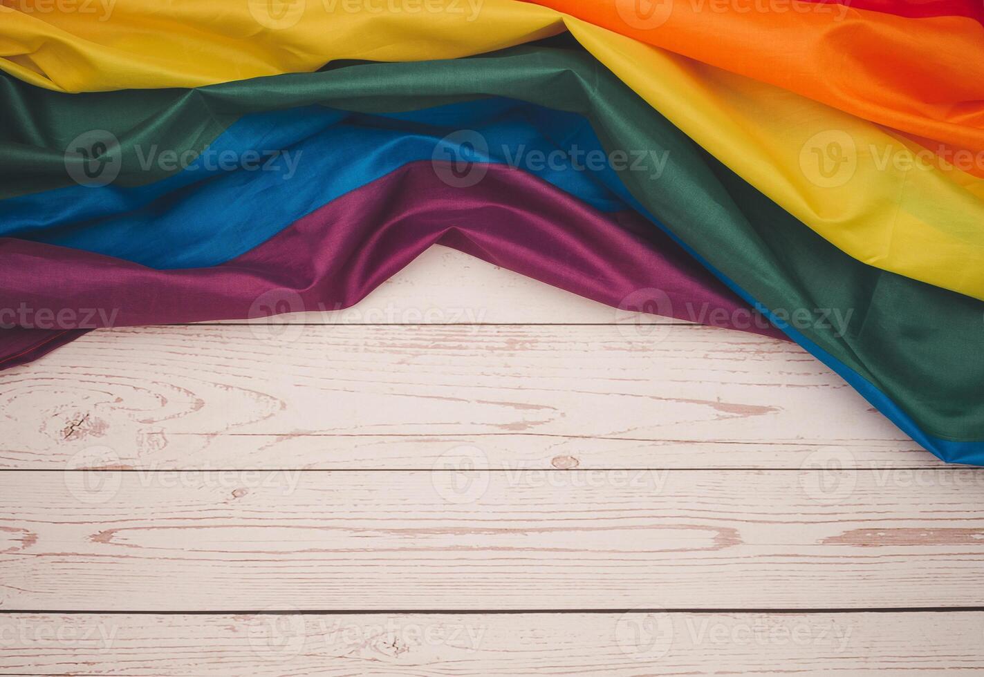 Top view of the rainbow flag on a wooden table. Space for text. photo