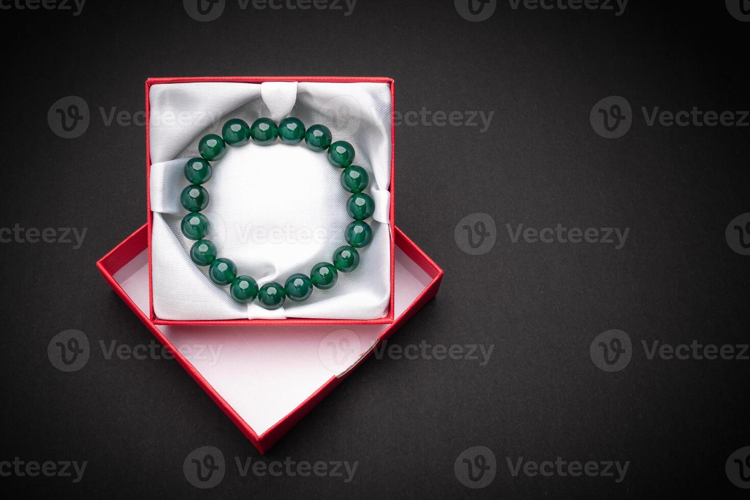 Close-up of a jade bangle or bracelet in a red box on a black background. photo