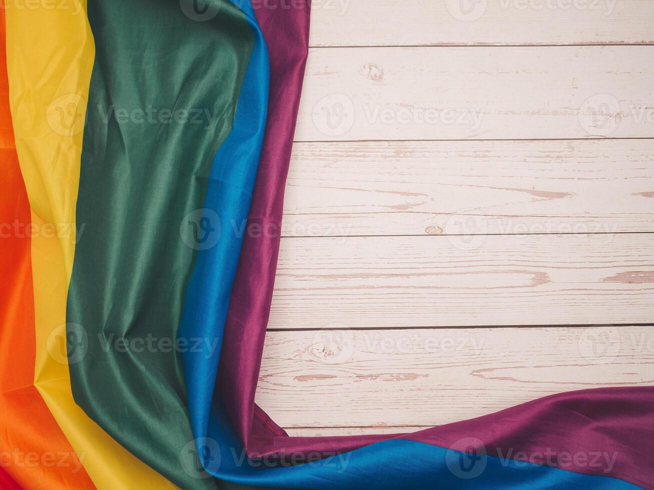 Top view of the rainbow flag on a wooden table. Space. photo