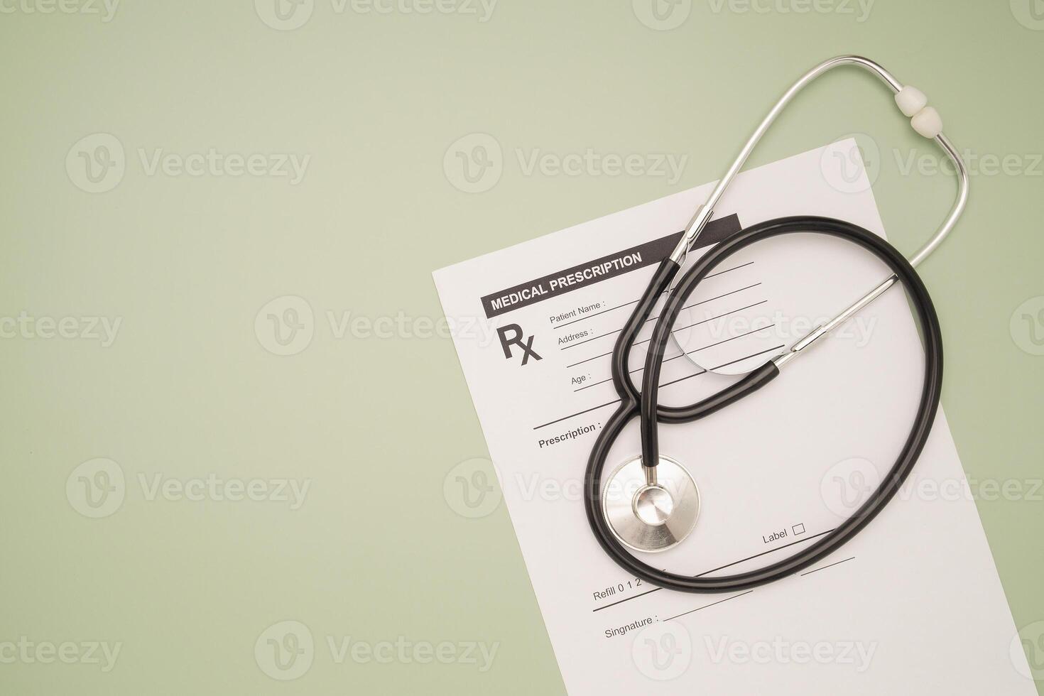 Top view of a stethoscope over the medical prescription sheet on a green background. Space for text. photo
