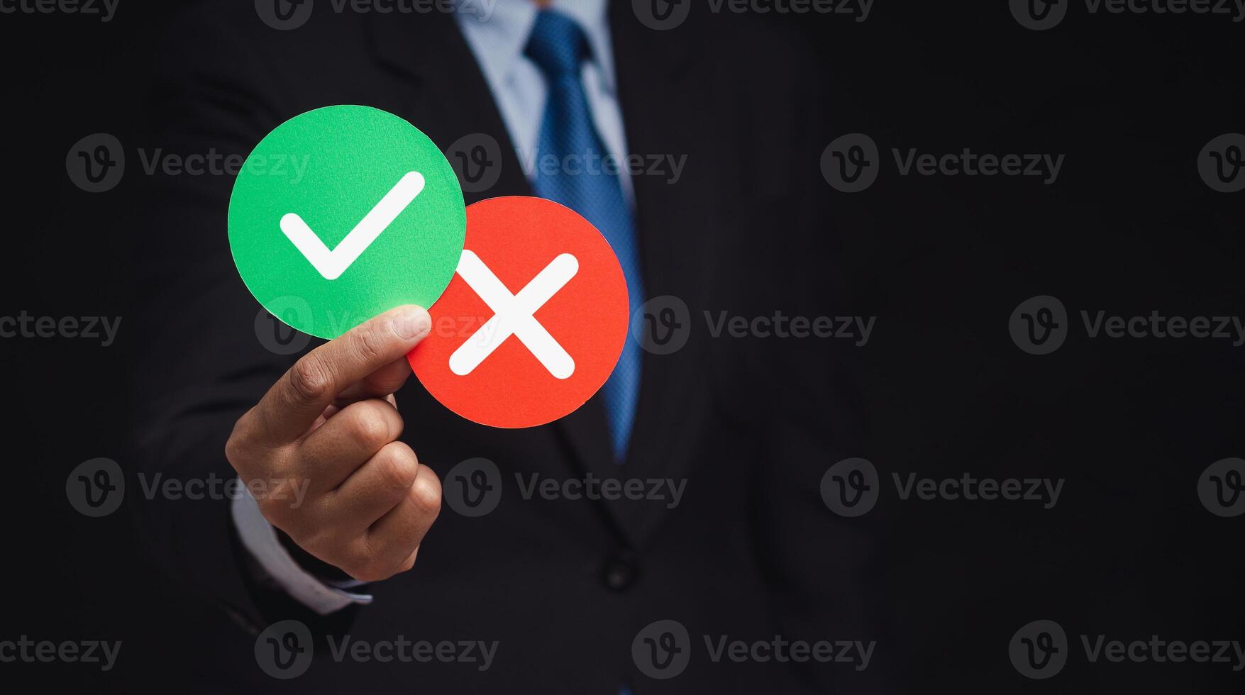 Businessman holding two papers circle shape with a checkmark and cross photo