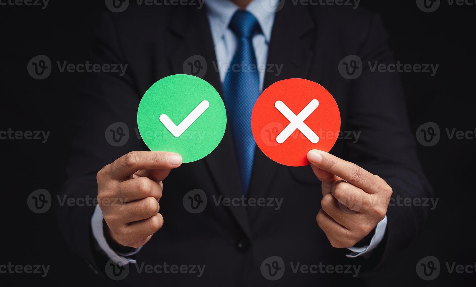 Businessman holding two papers circle shape with a checkmark and cross. photo