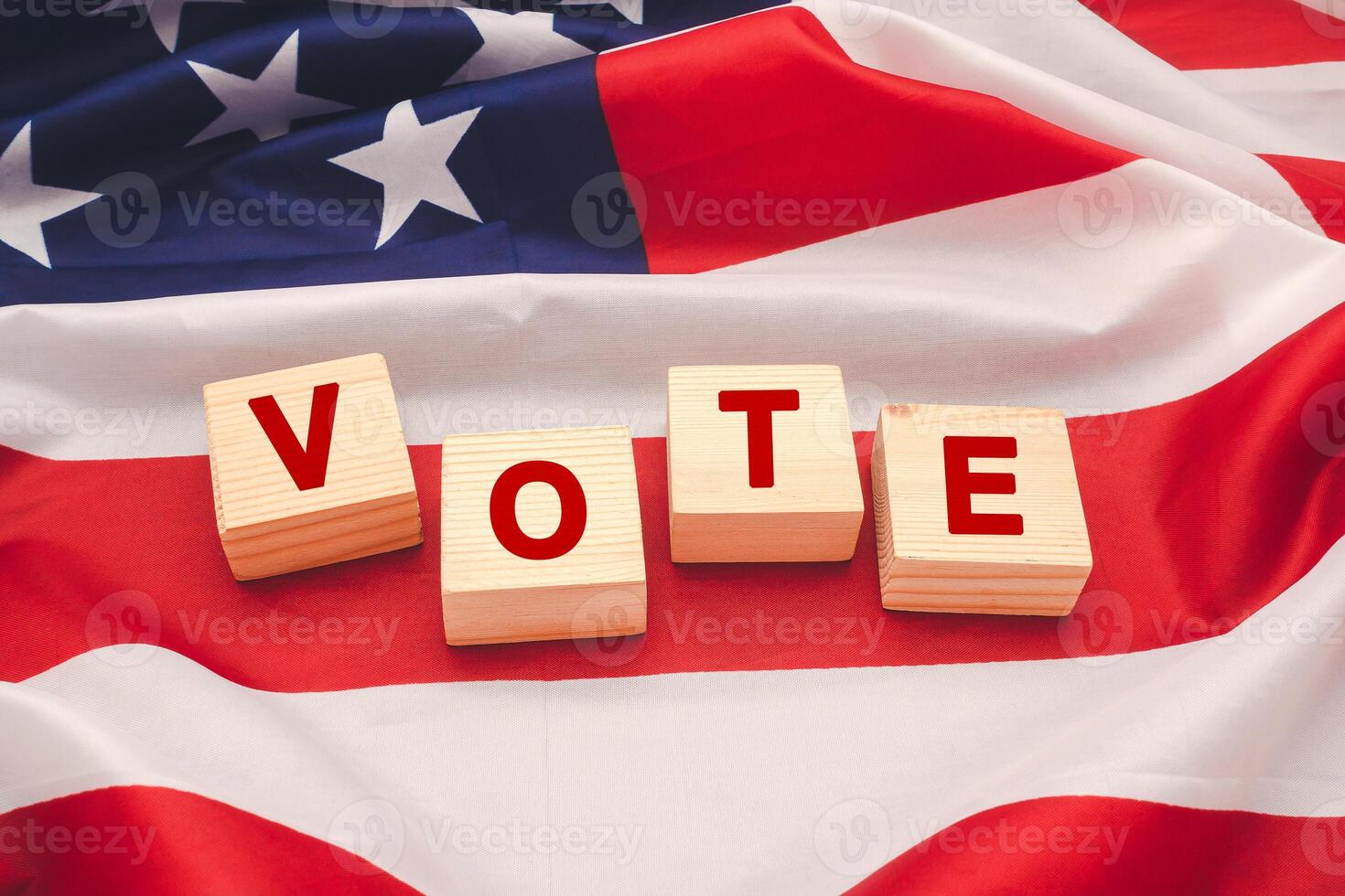 Top view of wooden cubes with letters VOTE over the American flag background. photo