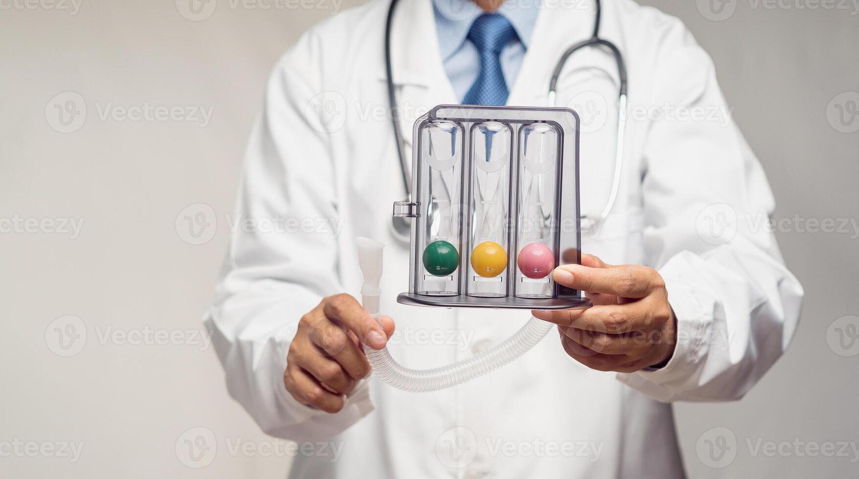 Close-up of a doctor holding an incentive spirometer to help perform deep breathing exercises while standing in the hospital. photo