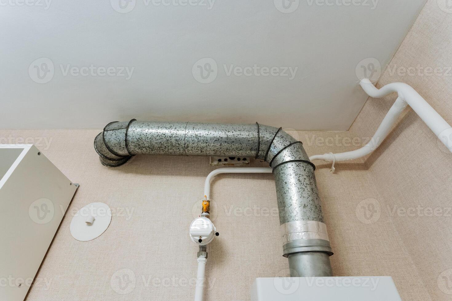 A metal pipe is currently suspended from the ceiling of a room, creating an intriguing focal point that may be part of the plumbing system or the infrastructure of the space photo