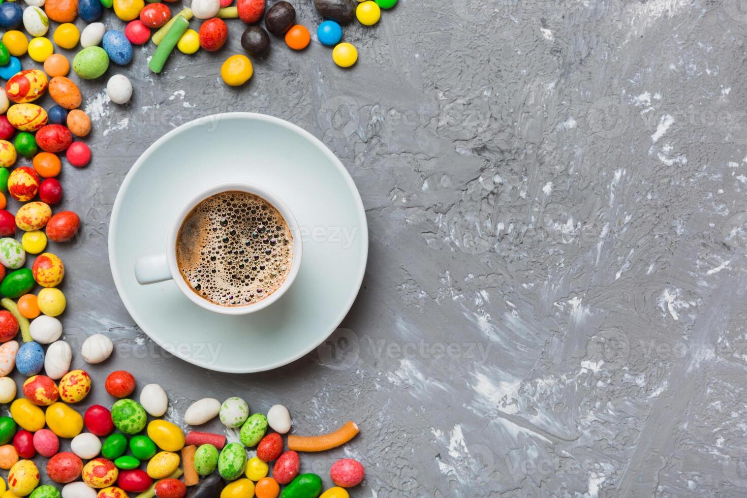 Coffee cup chocolates and colored candy. Top view table background copy space photo