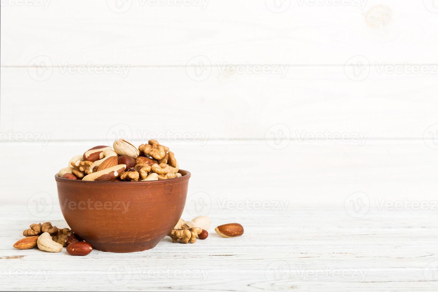 mixed nuts bowl. Mix various nuts colored background. pistachios, cashews, hazelnuts, peanuts and brazil nuts photo