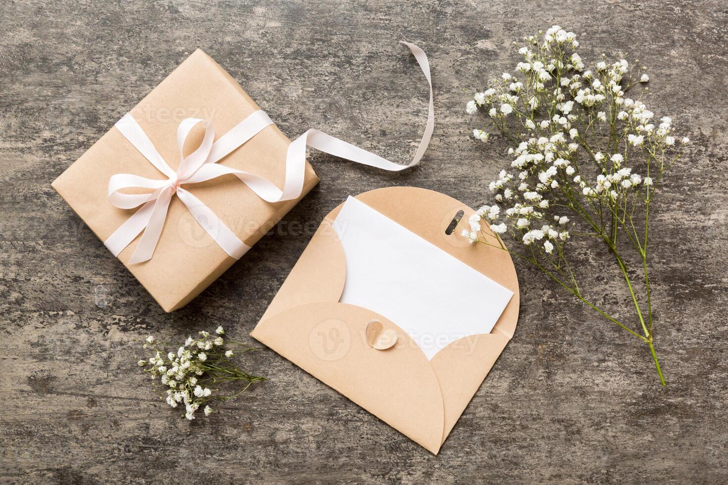 Wedding mockup with white paper list and flowers gypsophila on colored table top view flat lay. Blank greeting cards and envelopes.Beautiful floral pattern. photo