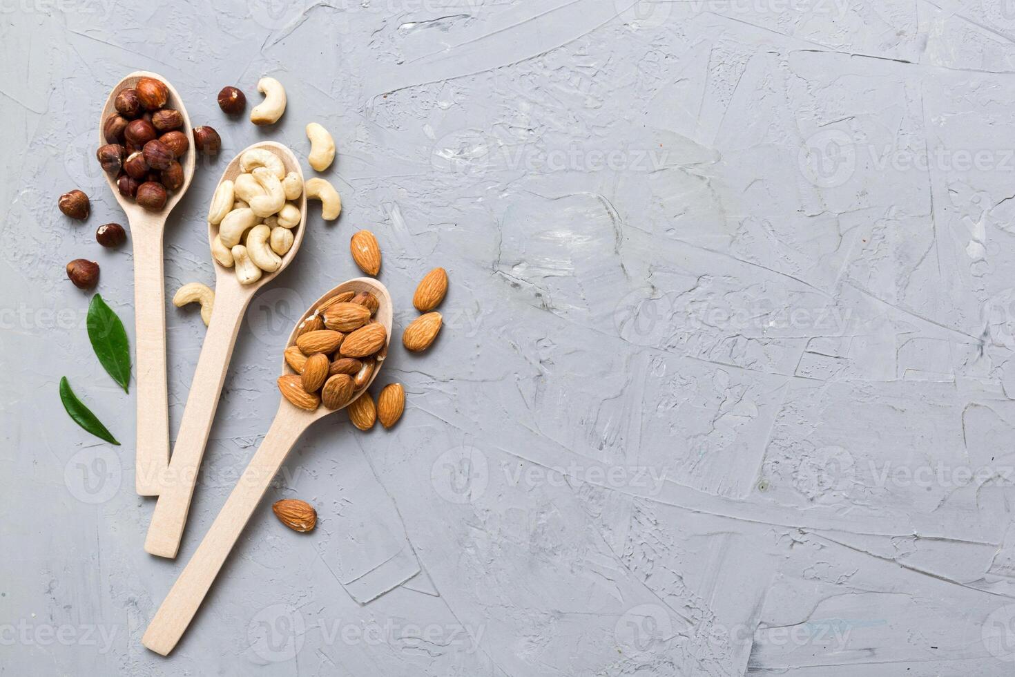 Assortment of nuts wooden spoon on colored table. Cashew, hazelnuts, walnuts, almonds. Mix of nuts Top view with copy space photo