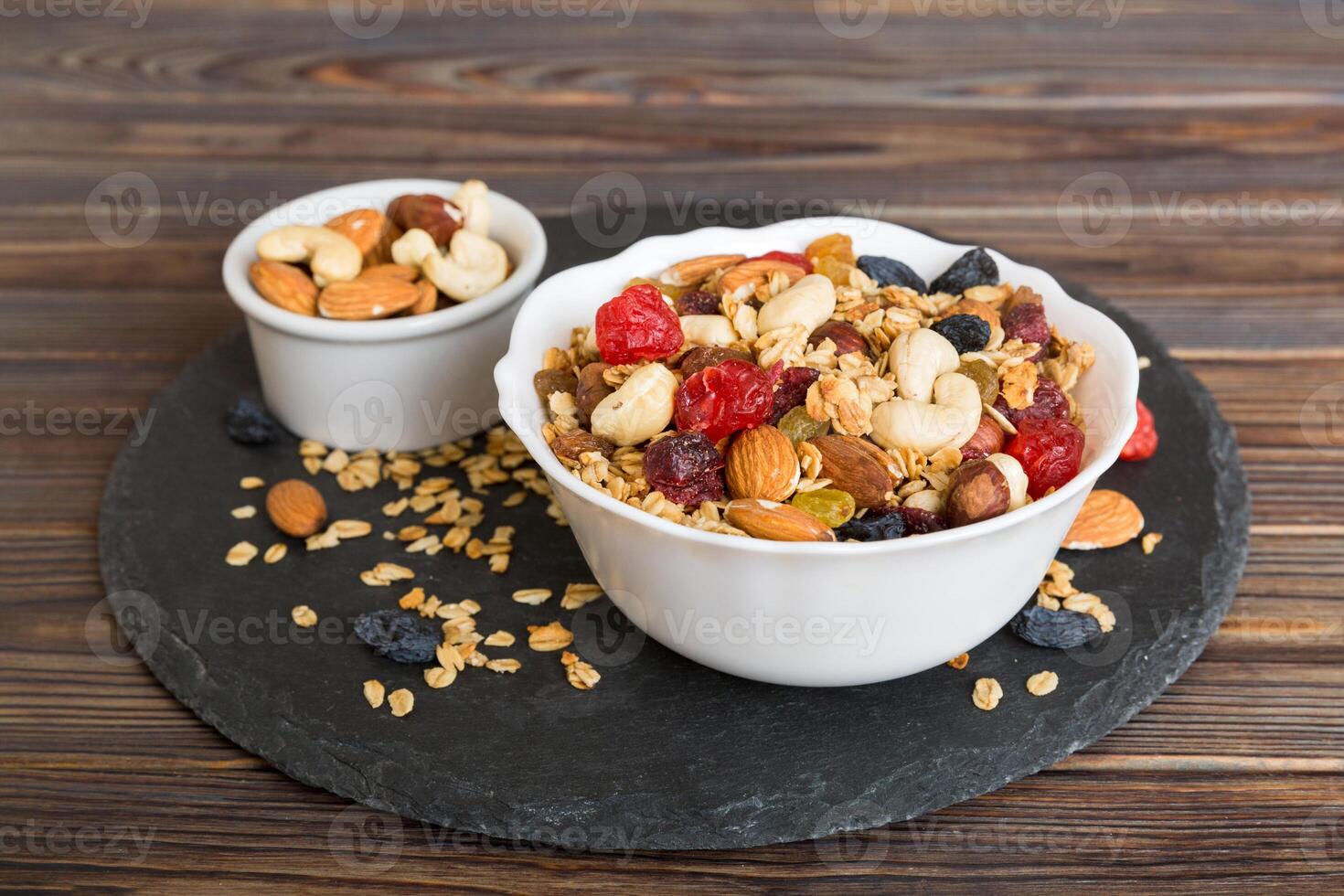 Cooking a wholesome breakfast. Granola with Various dried fruits and nuts in a bowl. The concept of a healthy dessert. Flat lay, top view photo