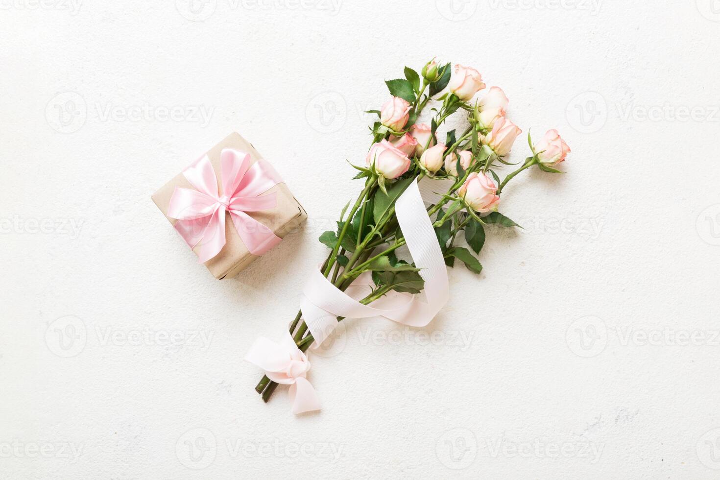 design concept with pink rose flower and gift box on colored table background top view. Happy Holiday, Mothers day, birthday concept. Romantic flat lay composition photo