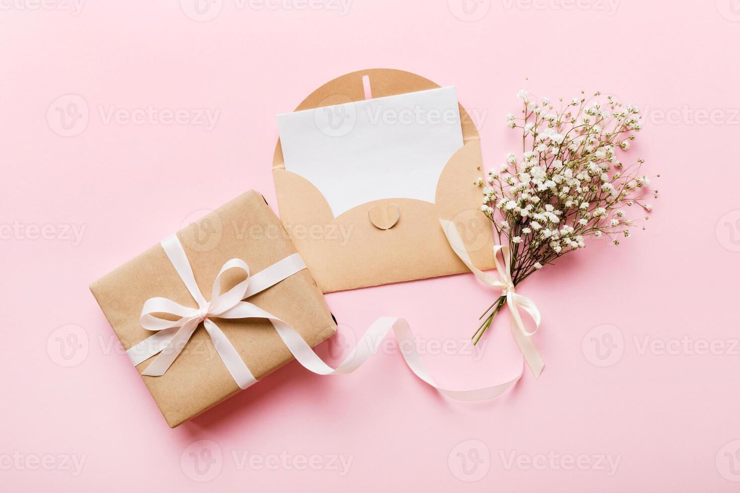 Wedding mockup with white paper list flowers gypsophila on colored table top view flat lay. Blank greeting cards and envelopes. Beautiful floral pattern photo