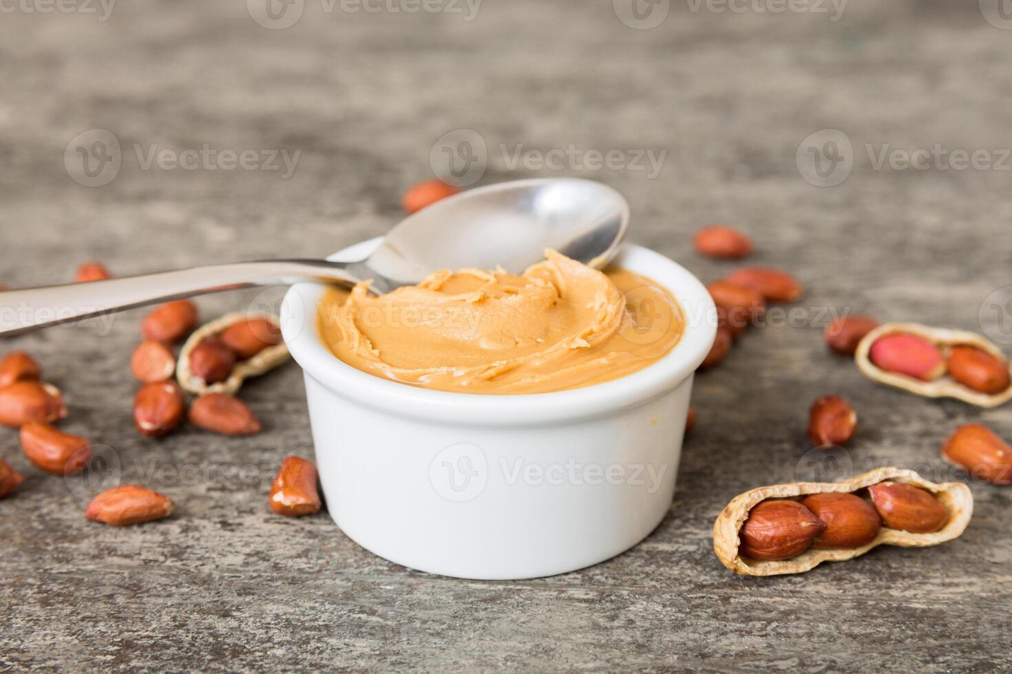 Bowl of peanut butter and peanuts table background. top view with copy space. Creamy peanut pasta photo
