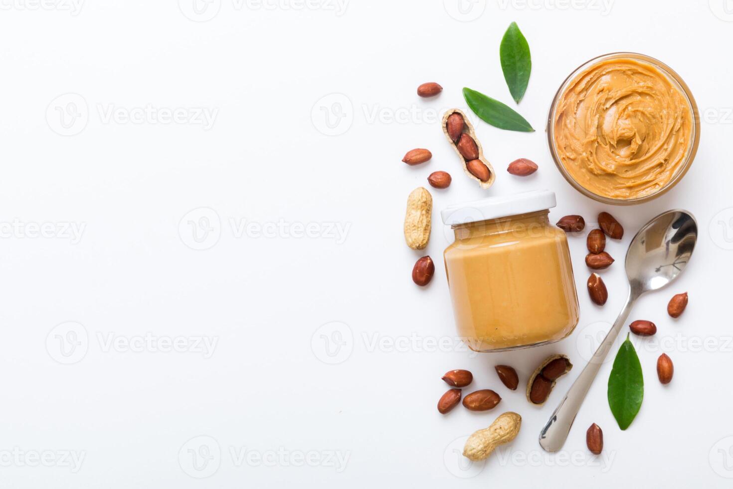 Bowl of peanut butter and peanuts table background. top view with copy space. Creamy peanut pasta in small bowl photo