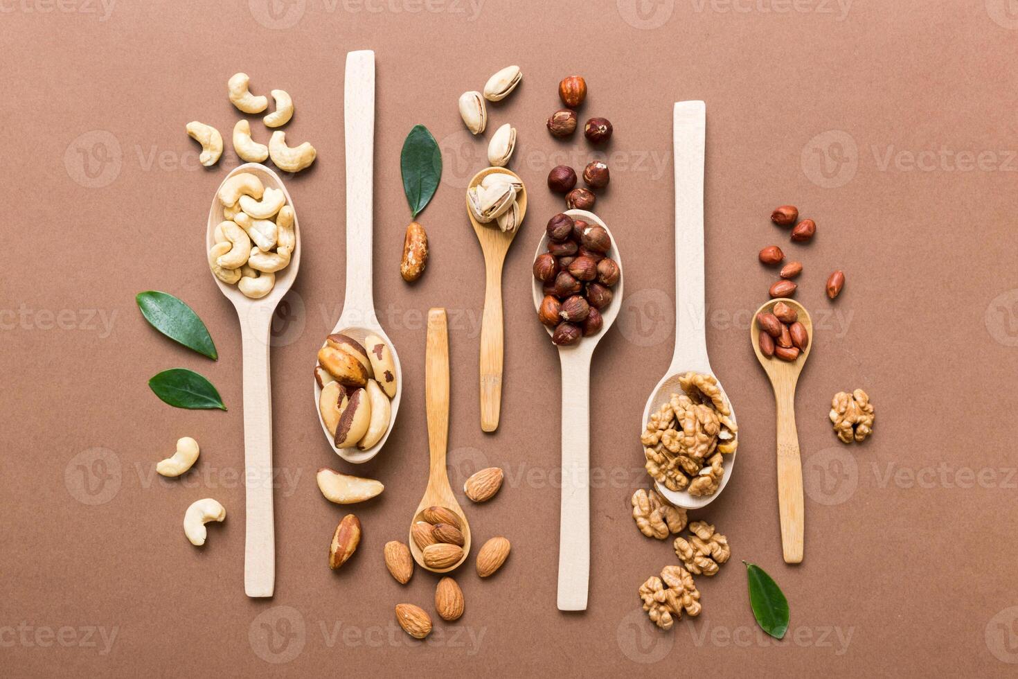 mixed nuts white wooden spoon. Mix of various nuts on colored background. pistachios, cashews, walnuts, hazelnuts, peanuts and brazil nuts photo