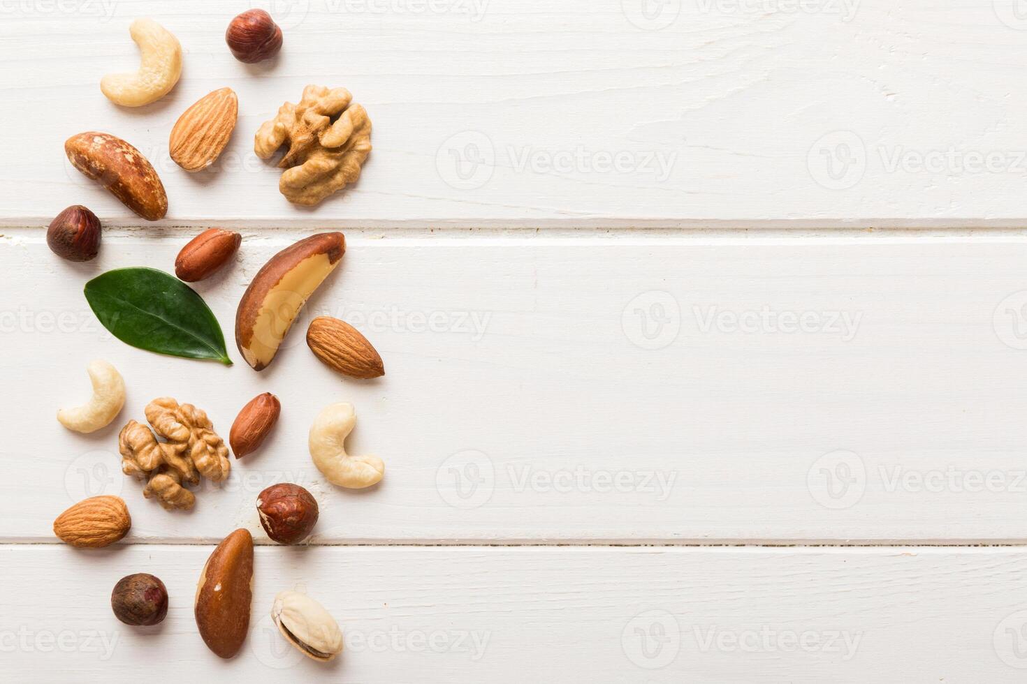 Composition of nuts , flat lay mix hazelnuts, cashews, almonds on table background. healthy eating concepts and food background photo