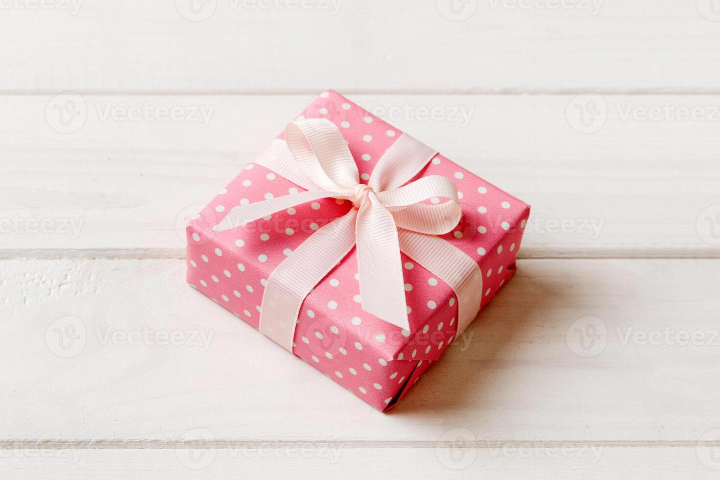 wrapped Christmas other holiday handmade gift box in color paper with ribbon on colored background. Present box, decoration of gift colored table, top view with copy space photo