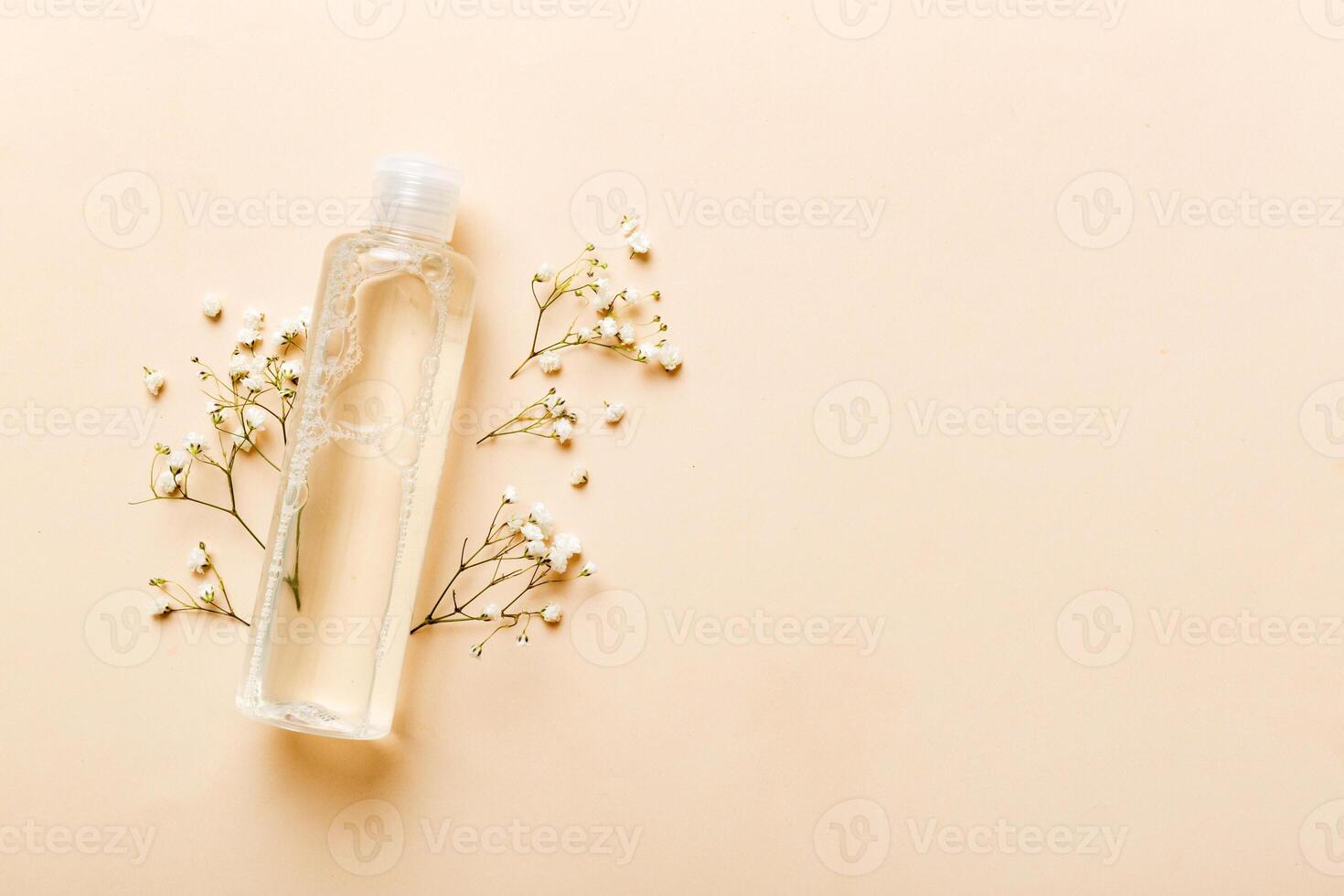 Fancy healthcare bottles for serum, micellar, toner, lotion, water and cream with gypsophila branch. Natural oranic spa cosmetics concept. Mockup, template, Top view photo