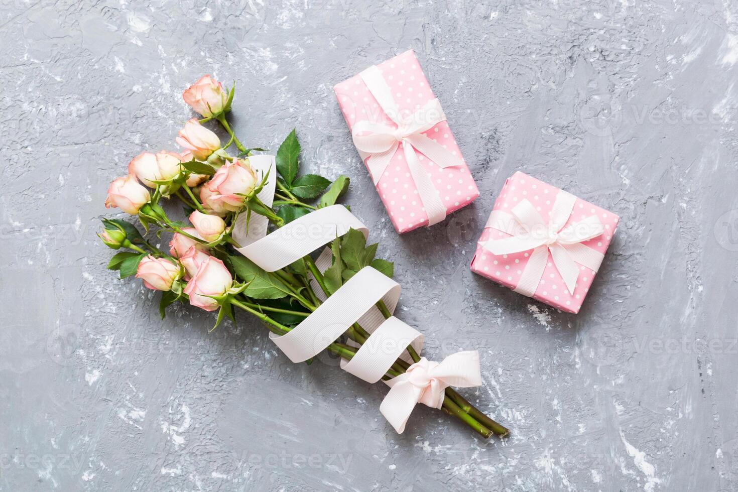 design concept pink rose flower and gift box on colored table background top view. Happy Holiday, Mothers day, birthday concept. Romantic flat lay composition photo
