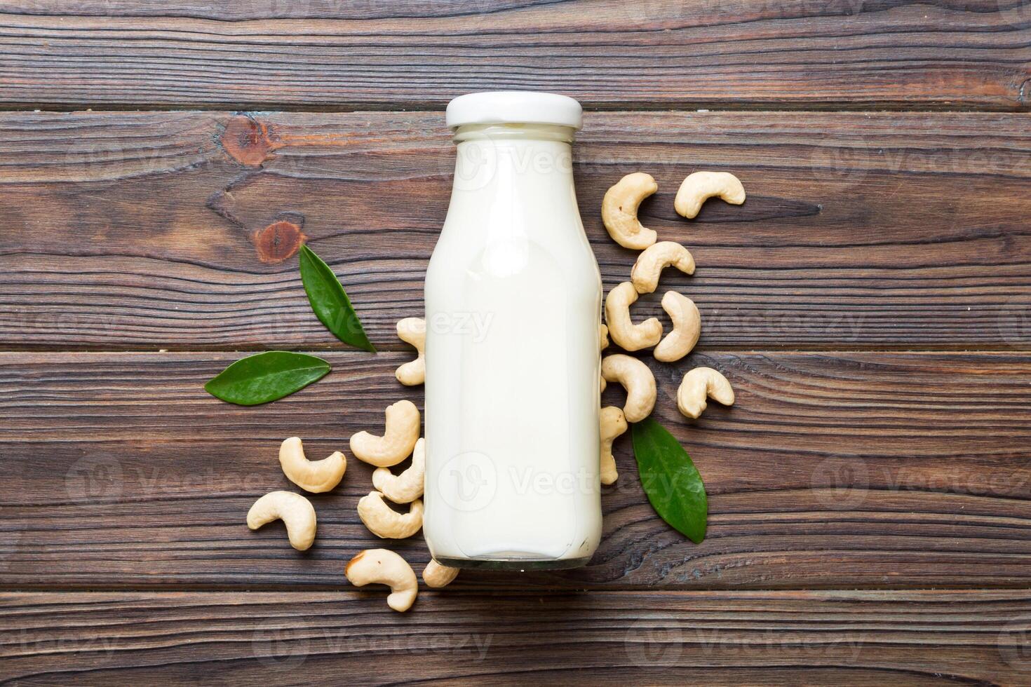 Vegan milk from cashews bottles on wooden table, Vegetarian alternative food, clean eating concept. top view with copy space photo