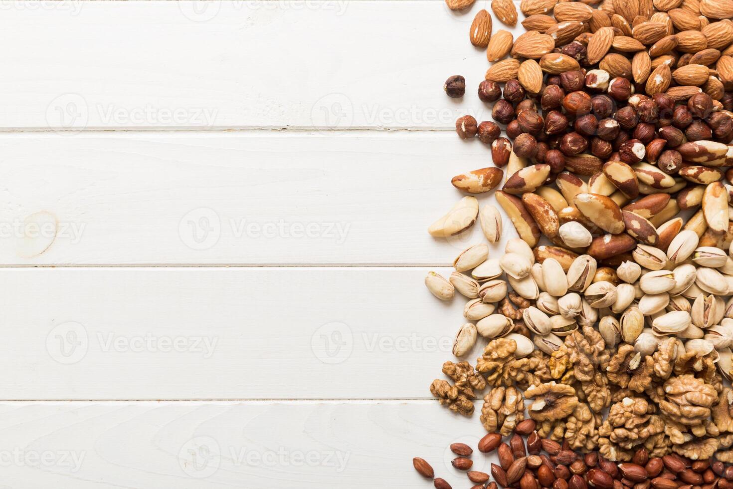different nuts frame background. Close up, top view, flat lay with vopy space. Walnut, pistachios, hazelnuts and cashews photo