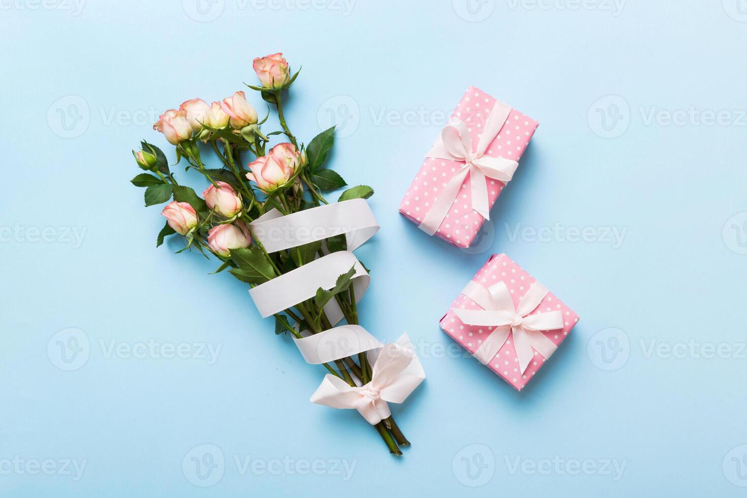 design concept with pink rose flower and gift box on colored table background top view. Happy Holiday, birthday concept. Romantic flat lay composition photo