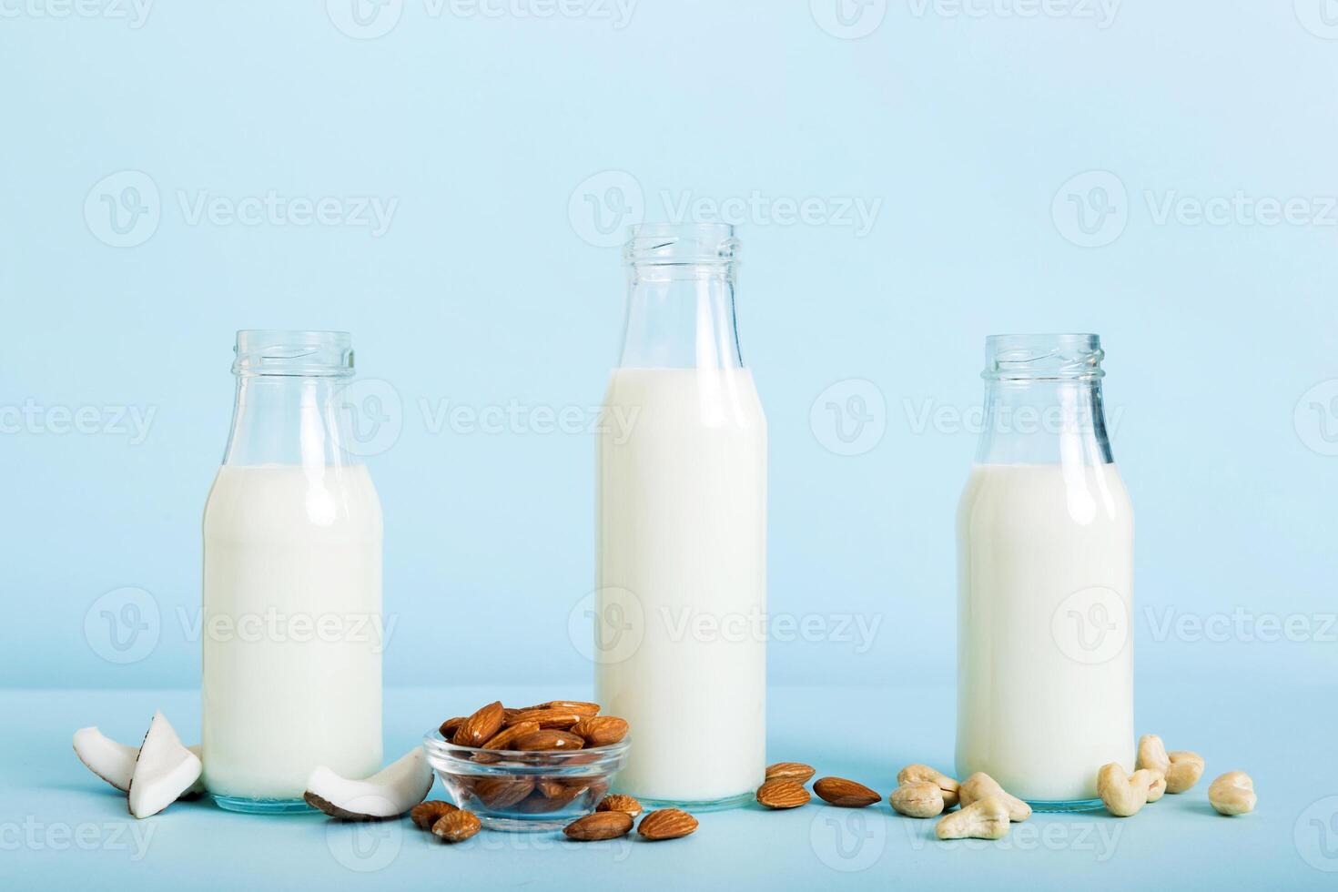 Set collection various vegan milk almond, coconut, cashew, on table background. Vegan plant based milk and ingredients, top view photo