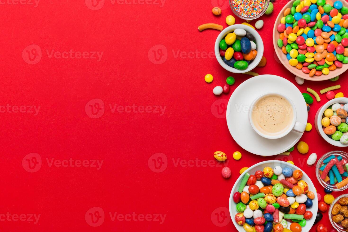 Coffee cup chocolates and colored candy. Top view on table background with copy space photo