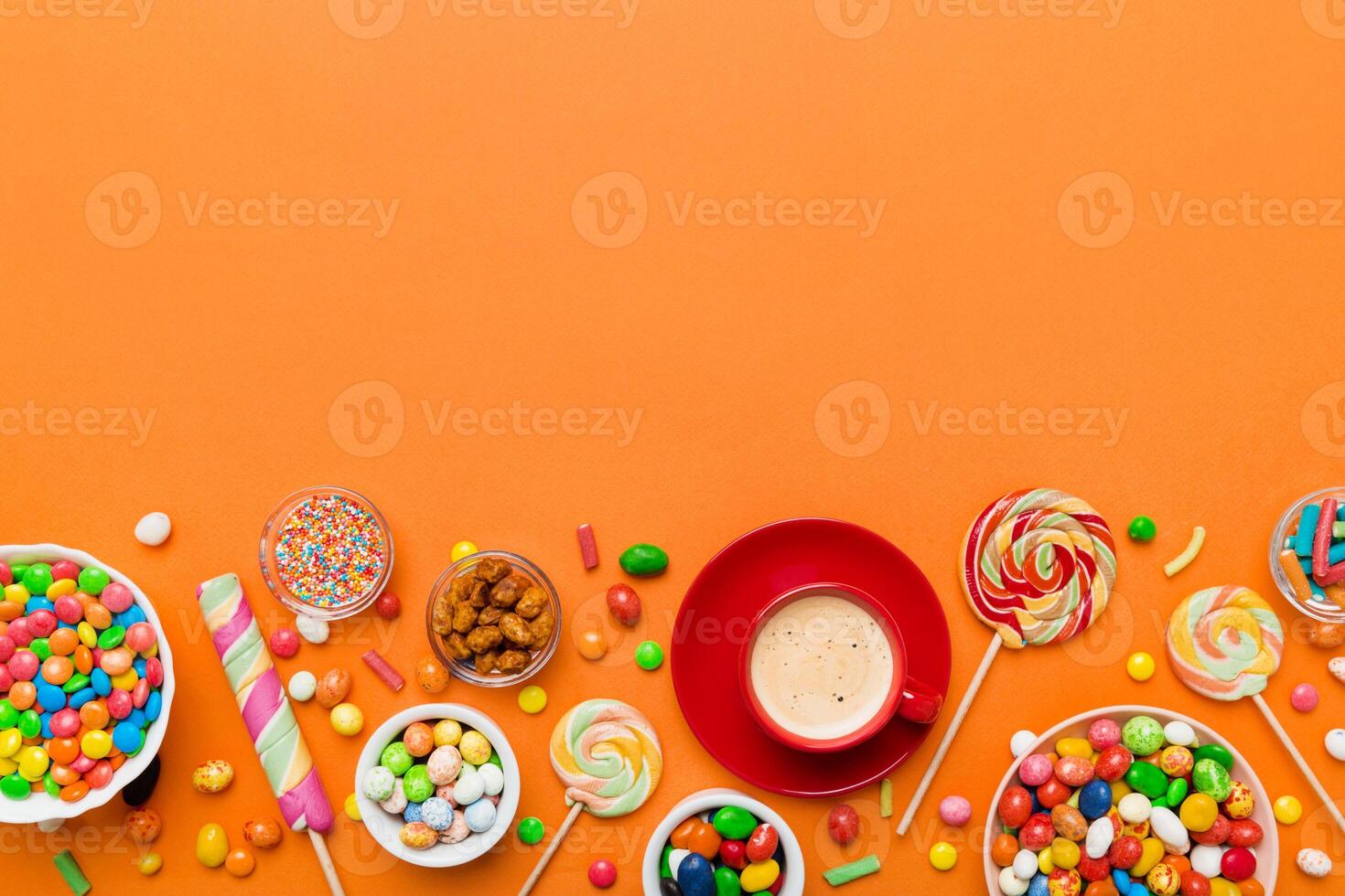 Coffee cup with chocolates and colored candy. table background with copy space photo