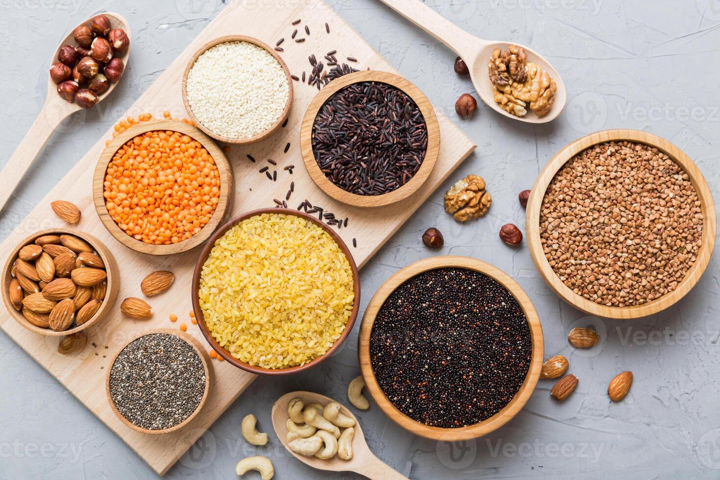 Various superfoods smal bowl colored background. Superfood as rice, chia, quinoa, lentils, nuts, sesame seeds, almonds. top view photo