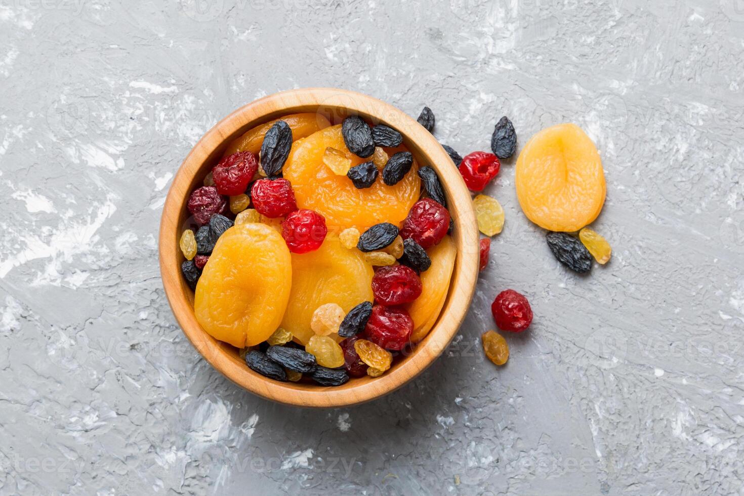 Bowl with different dried fruits table background, top view. Healthy lifestyle copy space photo