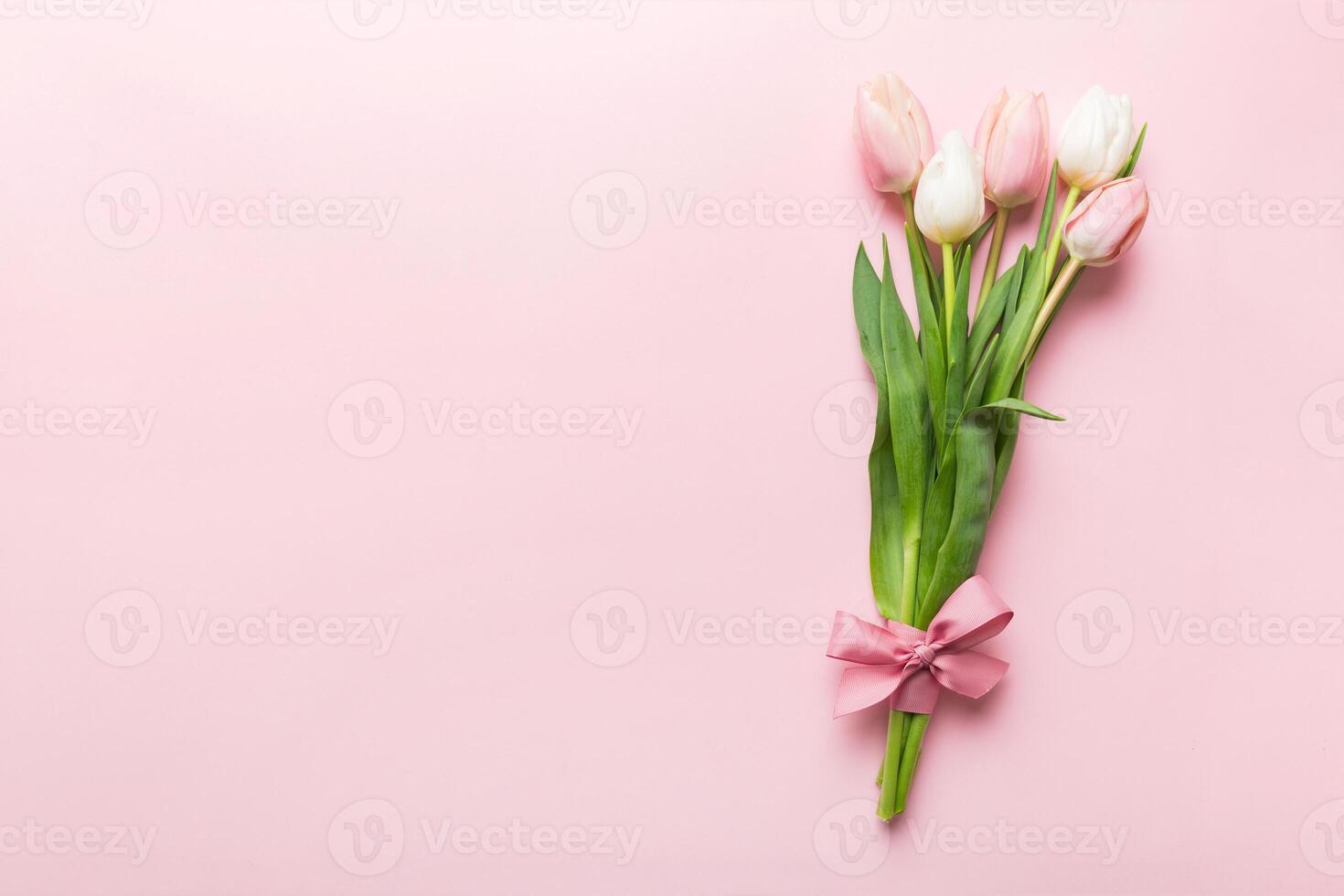 Bouquet of pink tulips colored table background . Top view with copy space. Waiting for spring. Happy Easter card. Flat lay photo