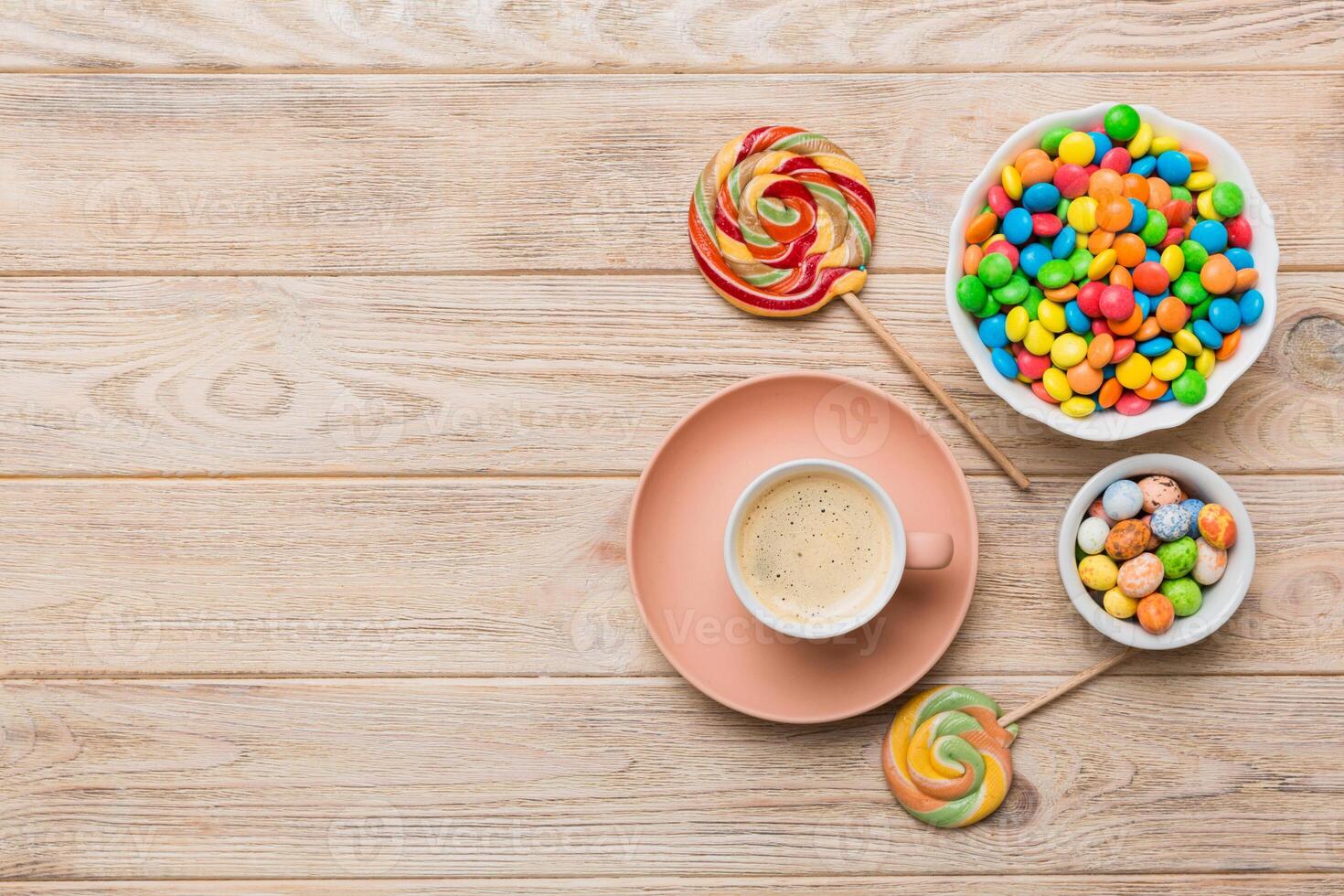 Coffee cup with chocolates and colored candy. Top view table background with copy space photo