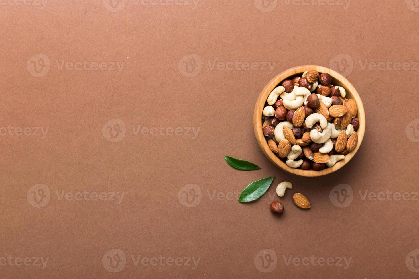 Assortment nuts wooden bowl colored table. Cashew, hazelnuts, walnuts, almonds. Mix nuts Top view with copy space photo