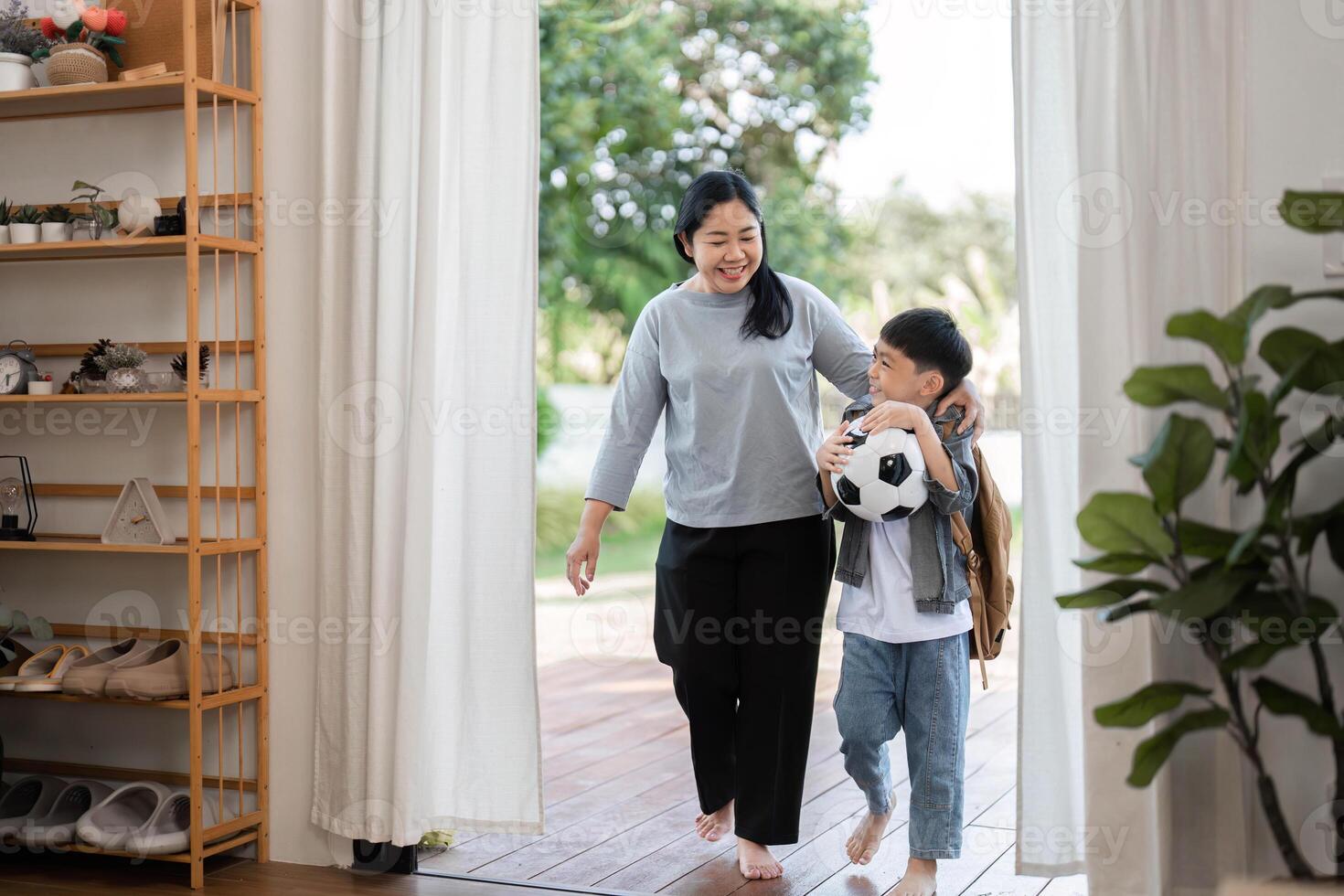 Outdoor Adventure and School Preparation. A mother and son stepping out together after packing for school. photo
