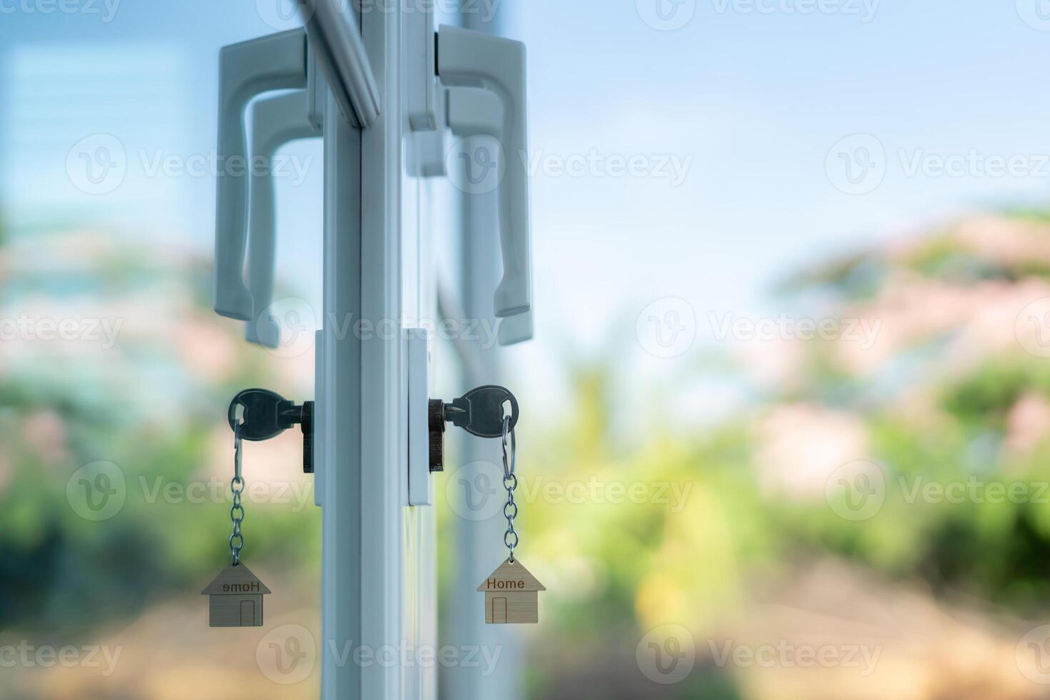 Landlord key for unlocking house is plugged into the door. Second hand house for rent and sale. keychain is blowing in the wind. mortgage for new home, buy, sell, renovate, investment owner estate photo