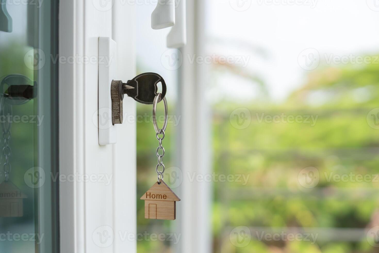 key for unlocking house is plugged into the door. Second hand house for rent and sale. keychain is blowing in the wind. mortgage for new home, buy, sell, renovate, investment, owner, estate. photo