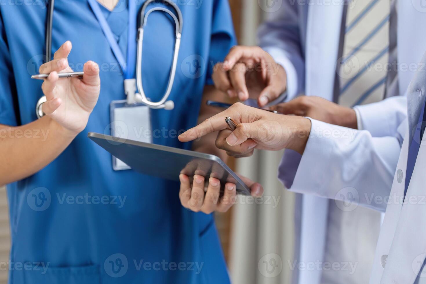 Doctor collaborating with team using tablet in medical consultation photo