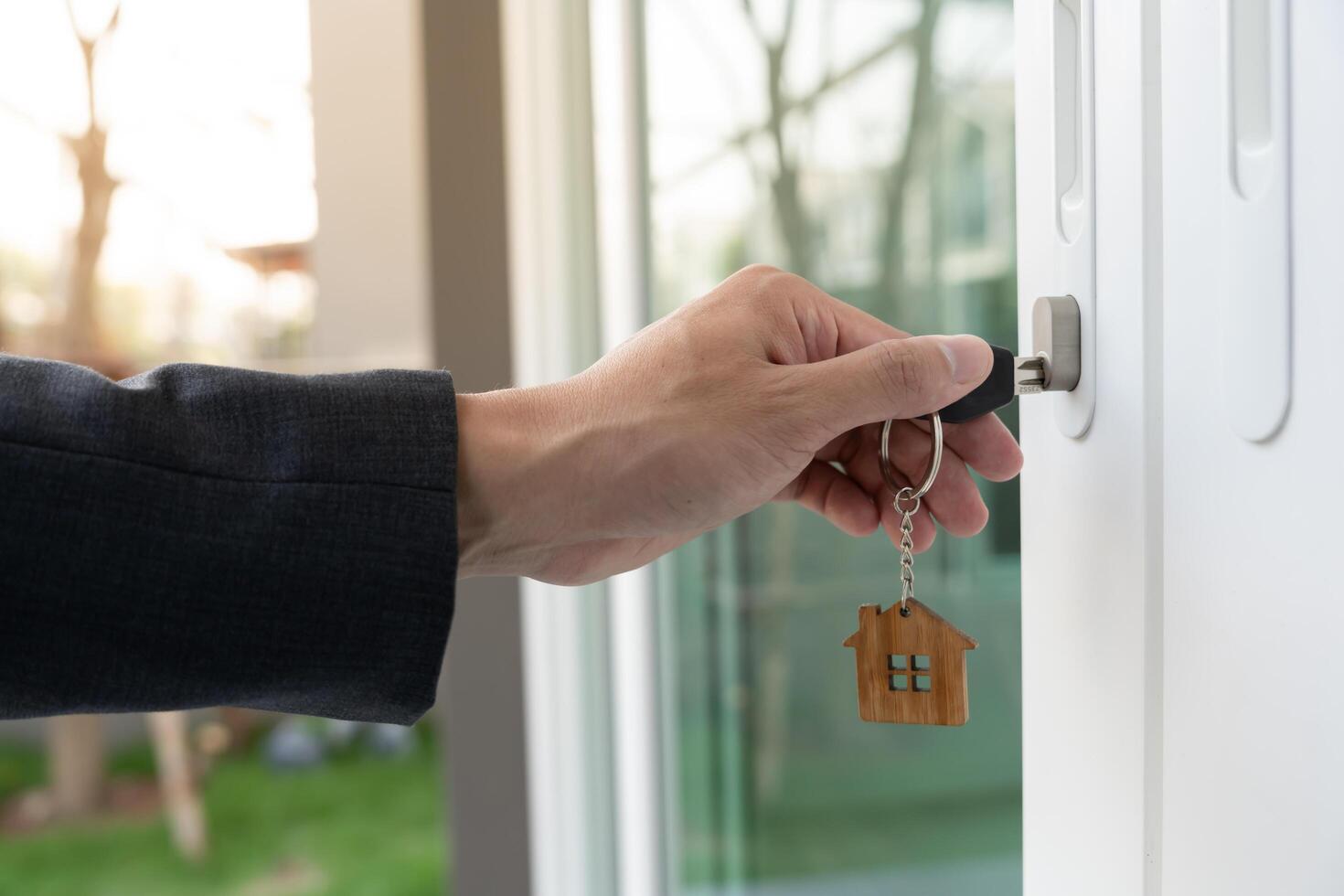 Landlord key for unlocking house is plugged into the door. Second hand house for rent and sale. Owner use hand unlock door mortgage for new home, buy, sell, renovate, investment, owner estate photo