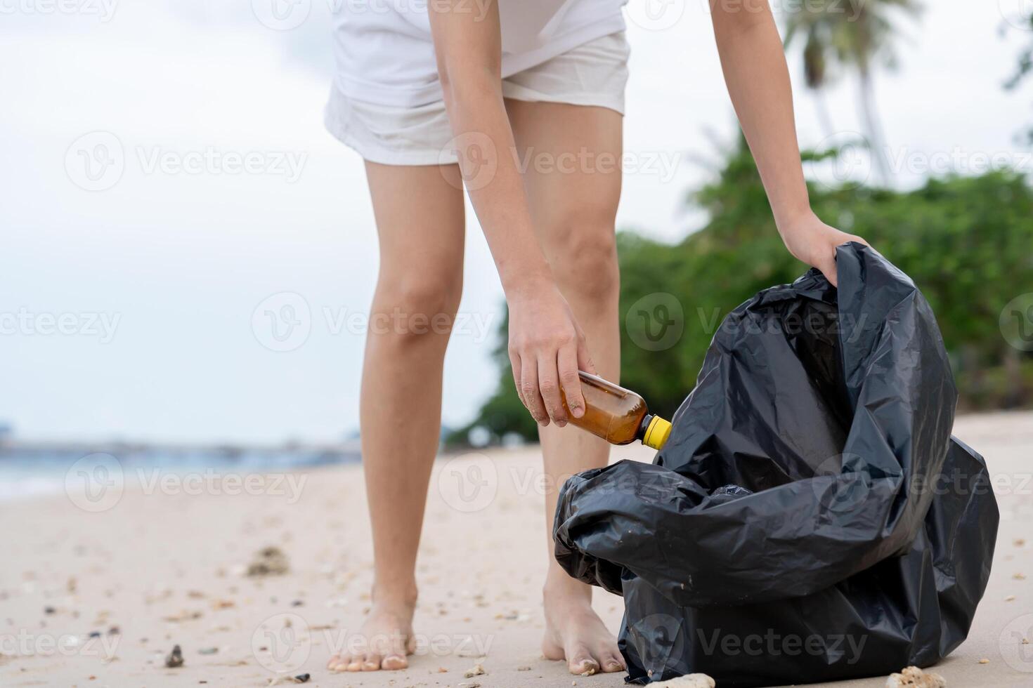 Save ocean, Volunteer pick up trash garbage at the beach and plastic bottles are difficult decompose prevent harm aquatic life. Earth, Environment, Greening planet, reduce global warming, Save world photo