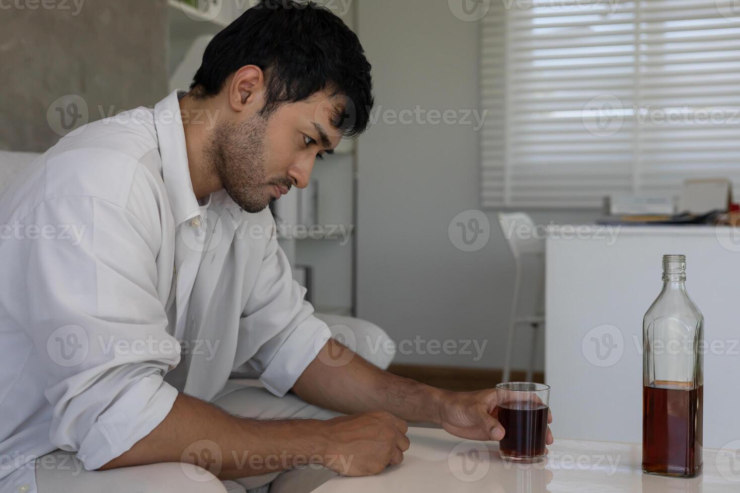 young business man addicted feeling bad drinking whiskey alone at home, stressed frustrated lonely drinking alcohol suffers from problematic liquor, alcoholism, life and family problems photo