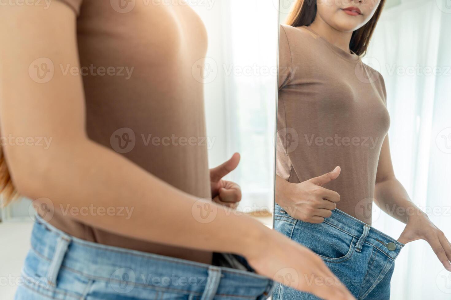 Women showing results of diet. Beautiful shape. female have a reduced waist size after under going a weight loss corse. can not wear jeans due to weight loss. balance. photo