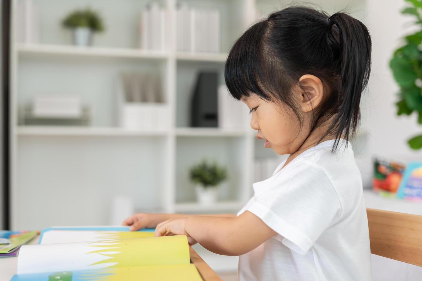 Happy Asian children girl relax read book at home. daughter and reading a story. learn development, childcare, laughing, education, storytelling, practice, imagine, reduce addiction mobile phone photo