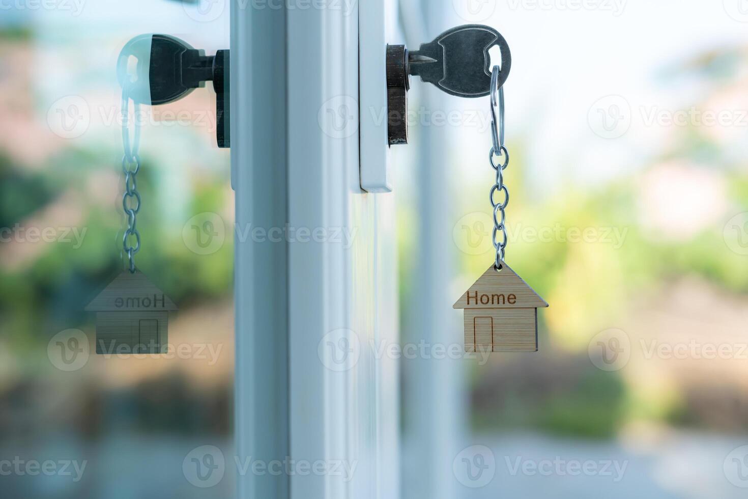 key for unlocking house is plugged into the door. Second hand house for rent and sale. keychain is blowing in the wind. mortgage for new home, buy, sell, renovate, investment owner, estate. photo