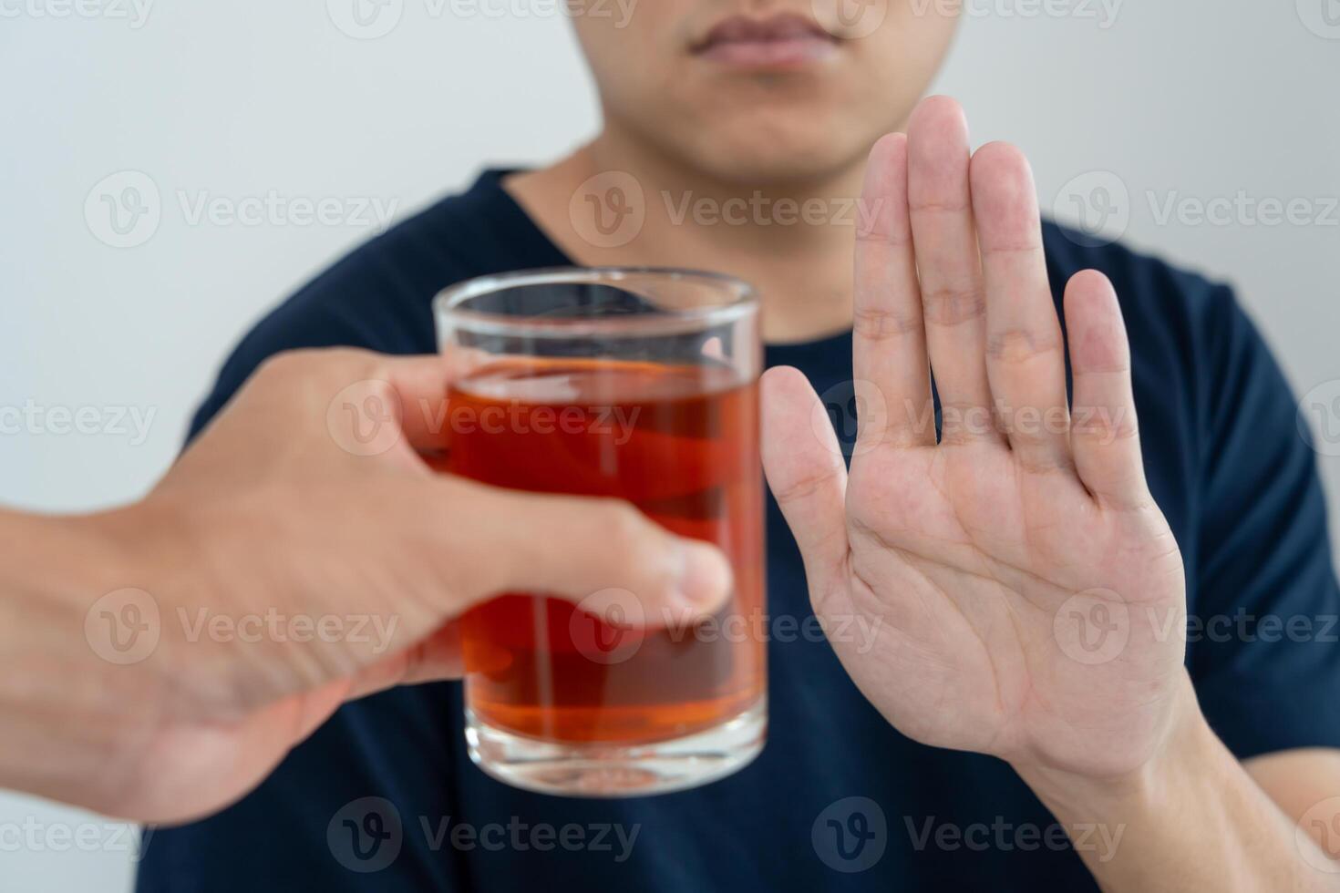 man refuses say no and avoid to drink an alcohol whiskey, stopping hand sign male, alcoholism treatment, alcohol addiction, quit booze, Stop Drinking Alcohol. Refuse Glass liquor unhealthy, reject photo
