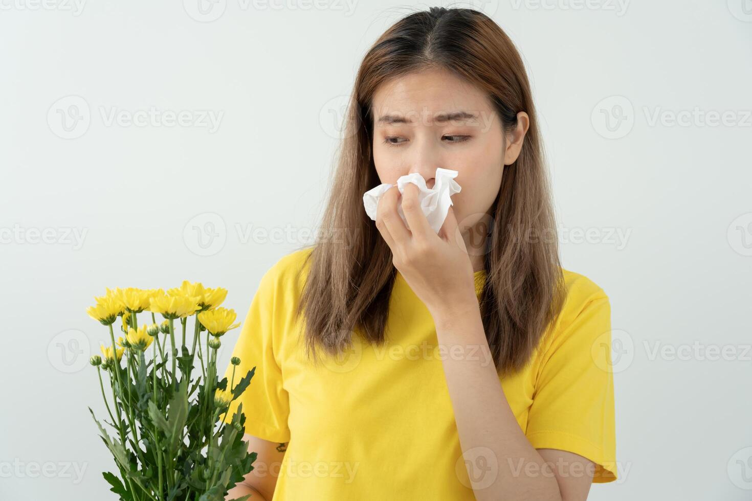 Pollen Allergies, asian young woman sneezing in a handkerchief or blowing in a wipe, allergic to wild spring flowers or blossoms during spring. allergic reaction, photo