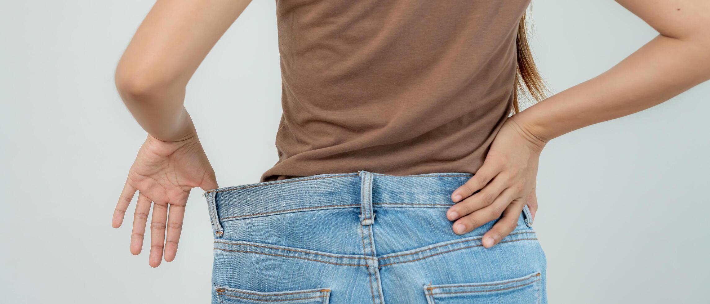 Women showing results of diet. Beautiful shape. female have a reduced waist size after under going a weight loss corse. can not wear jeans due to weight loss balance, control, routines, exercise. photo