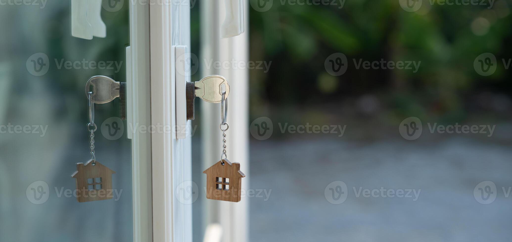 Landlord key for unlocking house is plugged into the door. Second hand house for rent and sale. keychain is blowing in the wind. mortgage for new home, buy, sell, renovate, photo