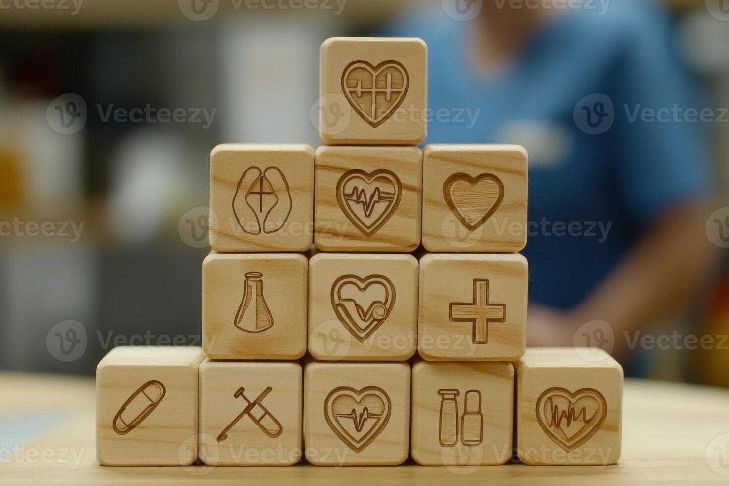 Wooden pyramid of medical icon blocks in caregiving scene with senior woman blurred behind photo